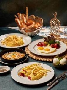 une table avec des assiettes de nourriture et des frites dans l'établissement Azal Lagoons Resort Abu Simbel, à Abou Simbel