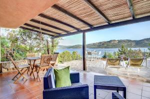 a patio with a table and chairs and a view of the water at VILLA MARIA - CAPO D'ORSO - HOME and MORE in Palau