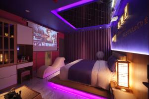 a bedroom with a bed and a tv and purple lights at Chiic House 6 - Khách sạn tình yêu in Vung Tau +43 photos