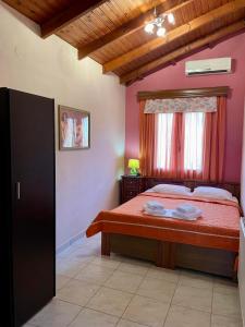 een slaapkamer met een bed met rode lakens en een raam bij Ariadni Hotel Bungalows in Skala Potamias