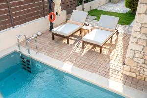 two chairs and a table and a swimming pool at Lydia's Inn 1 - Private pool, near Xylokastro in Melíssion