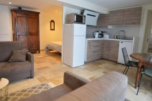 uma cozinha e sala de estar com um sofá e um frigorífico em Cinégîte du jardin aux étoiles - Proche de Saint Emilion em Saint-Pey-de-Castets