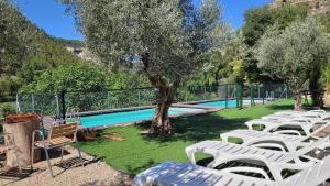 a group of white lounge chairs next to a swimming pool at Casa Rural El Molinar in Albacete