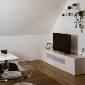 a living room with a tv on a white cabinet at Apartman BUCO in Đakovo