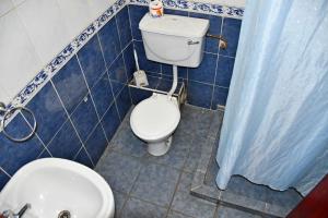 y baño con aseo blanco y lavamanos. en YWCA Parkview Suites, en Nairobi