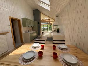 a kitchen with a table with plates and red cups at Dom w Starym Sadzie z basenem i sauną - Beskid Wyspowy in Nowe Rybie