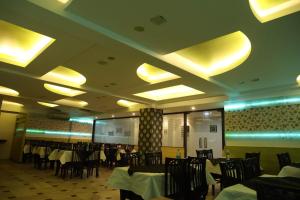 a dining room with tables and chairs and yellow lights at Hotel Panna Paradise in Agra