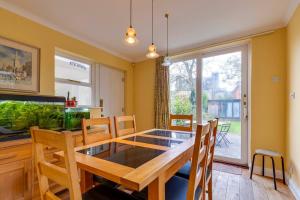 ケンブリッジにあるPass the Keys Spacious Victorian Home with Free Parkingのテーブルと椅子と窓のあるダイニングルーム