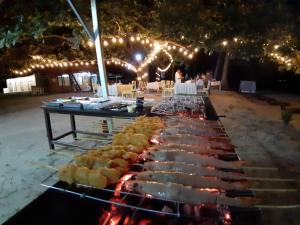 a buffet of food on a grill with lights at New Belitung Holiday Resort in Pasarbaru