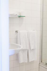 y baño con toallas blancas y lavamanos. en Hotel Restaurant BEAU, en Bergeijk
