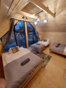 une chambre avec deux lits dans une cabane en rondins dans l'établissement VIP Celebrity House przy Suntago, Grabska Osada Apartamenty, à Mszczonów