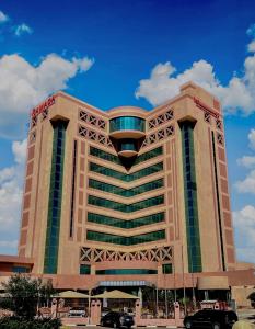 a large building with a blue sky in the background at Ramada Hotel & Suites by Wyndham Al Qassim in Al Bukayriyah