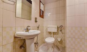 La salle de bains est pourvue de toilettes blanches et d'un lavabo. dans l'établissement FabHotel Shekhawati Palace, à Jaipur
