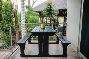 una mesa negra y bancos en un balcón en Addo Alkham Lodge, en Sunland