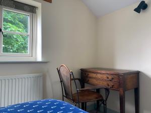 een slaapkamer met een bureau en een stoel naast een raam bij Farmhouse studio near Shrewsbury in Shrewsbury