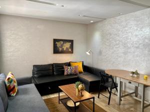 een woonkamer met een zwarte bank en een tafel bij Superbe appartement très bien situé in Casablanca