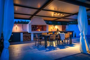 an outdoor kitchen and dining area with a table and chairs at Villa Luna Luxury apartment in Skradin