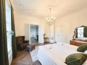 a bedroom with a bed and a chandelier at Strandnäs Gård in Mariehamn