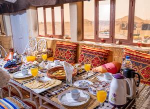a table with food and orange juice on it at Aladdin Desert Camp - Mhamid Erg Chigaga Escape in El Gouera