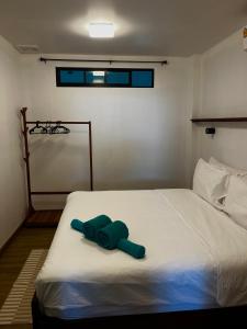 a bedroom with a bed with two green towels on it at Koh Tao studios in Ko Tao