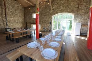 einem langen Holztisch mit Tellern und Gläsern darauf in der Unterkunft Villa de luxe, nichée dans les montagnes in Lavoine