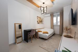 Schlafzimmer mit einem Bett, einem Schreibtisch und einem TV in der Unterkunft Comanda LUXURY APARTMENTS in Belgrad