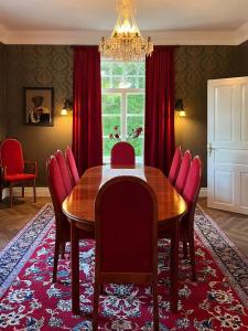 uma sala de jantar com uma mesa de madeira e cadeiras vermelhas em Strandnäs Gård em Mariehamn