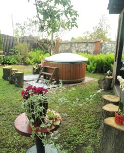 un jardín con bañera de hidromasaje y una mesa con flores en Garden View Home en Mārupe