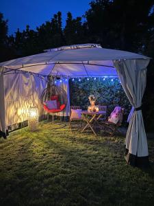 a tent with chairs and a table in a yard at night at Blue Village Lux in Kolašin