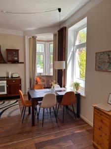 sala de estar con mesa de comedor y sillas en Schöne Altbauwohnung direkt an der Kesselschleuse! en Emden