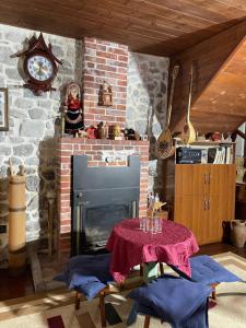 sala de estar con chimenea de ladrillo y mesa en Kompleksi Zorgji, en Theth