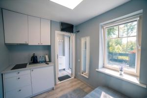 a kitchen with white cabinets and a window at Unique place by the beach in Klaipėda