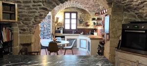 une cuisine avec une table dans un mur en pierre dans l'établissement Grande maison de Village, à Villevieille