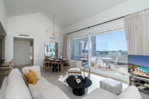 sala de estar con sofá blanco y TV en AL-321 Penthouse 3 bedrooms Alcazaba Lagoon, en Estepona