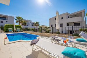 a swimming pool with chaise lounge chairs and a pool at Luxury apartment Hyperion with private pool and garden in Murter