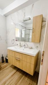 a bathroom with a sink and a mirror at Lydia's Inn 2 - Private pool, near Xylokastro in Melission