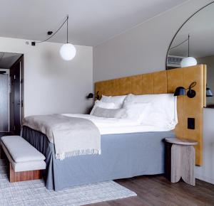 um quarto com uma cama grande e uma cabeceira em madeira em Clarion Hotel Helsinki Airport em Vantaa