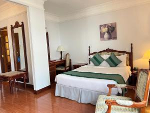 1 dormitorio con 1 cama, mesa y sillas en Riverside Hotel Saigon, en Ho Chi Minh