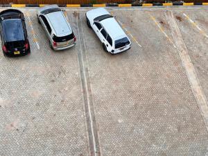 dos autos estacionados en un estacionamiento uno al lado del otro en Luxurious 2 bedroom penthouse-Fully Furnished, en Kitale