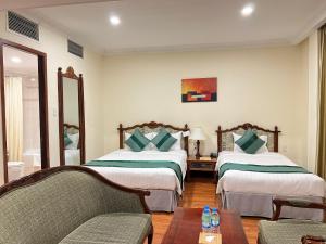 Habitación de hotel con 2 camas y mesa en Riverside Hotel Saigon, en Ho Chi Minh