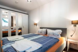 Schlafzimmer mit einem Bett mit blauer Bettwäsche und Kissen in der Unterkunft Sellinkoje in Residenz Waldidyll in Ostseebad Sellin