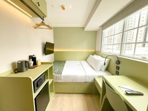 Habitación pequeña con cama y escritorio. en Urbanwood Hung Hom en Hong Kong