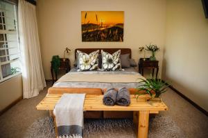 een slaapkamer met een bed en een tafel met schoenen erop bij Addo Alkham Lodge in Sunland +150 foto's
