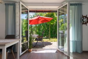 eine offene Glasschiebetür mit einem Sonnenschirm auf einer Terrasse in der Unterkunft Sellinkoje in Residenz Waldidyll in Ostseebad Sellin