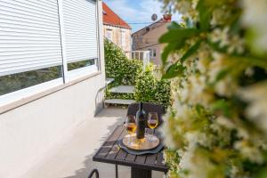 two glasses of wine sitting on a table on a balcony at Apartments Regjo in Dubrovnik