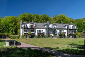 ein großes Haus mit einem davor geparkt in der Unterkunft Sellinkoje in Residenz Waldidyll in Ostseebad Sellin