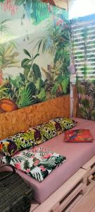 two pillows on a bed in front of a mural at каравана ТРОПИК-ЕКЗОТИК А 17 in Sozopol