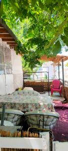 a patio with a table and chairs under a tree at каравана ТРОПИК-ЕКЗОТИК А 17 in Sozopol +22 photos