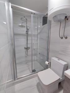 een witte badkamer met douche en toilet bij Melograno in Tivat