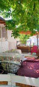 une table et des chaises sur une terrasse sous un arbre dans l'établissement каравана ТРОПИК-ЕКЗОТИК А 17, à Sozopol